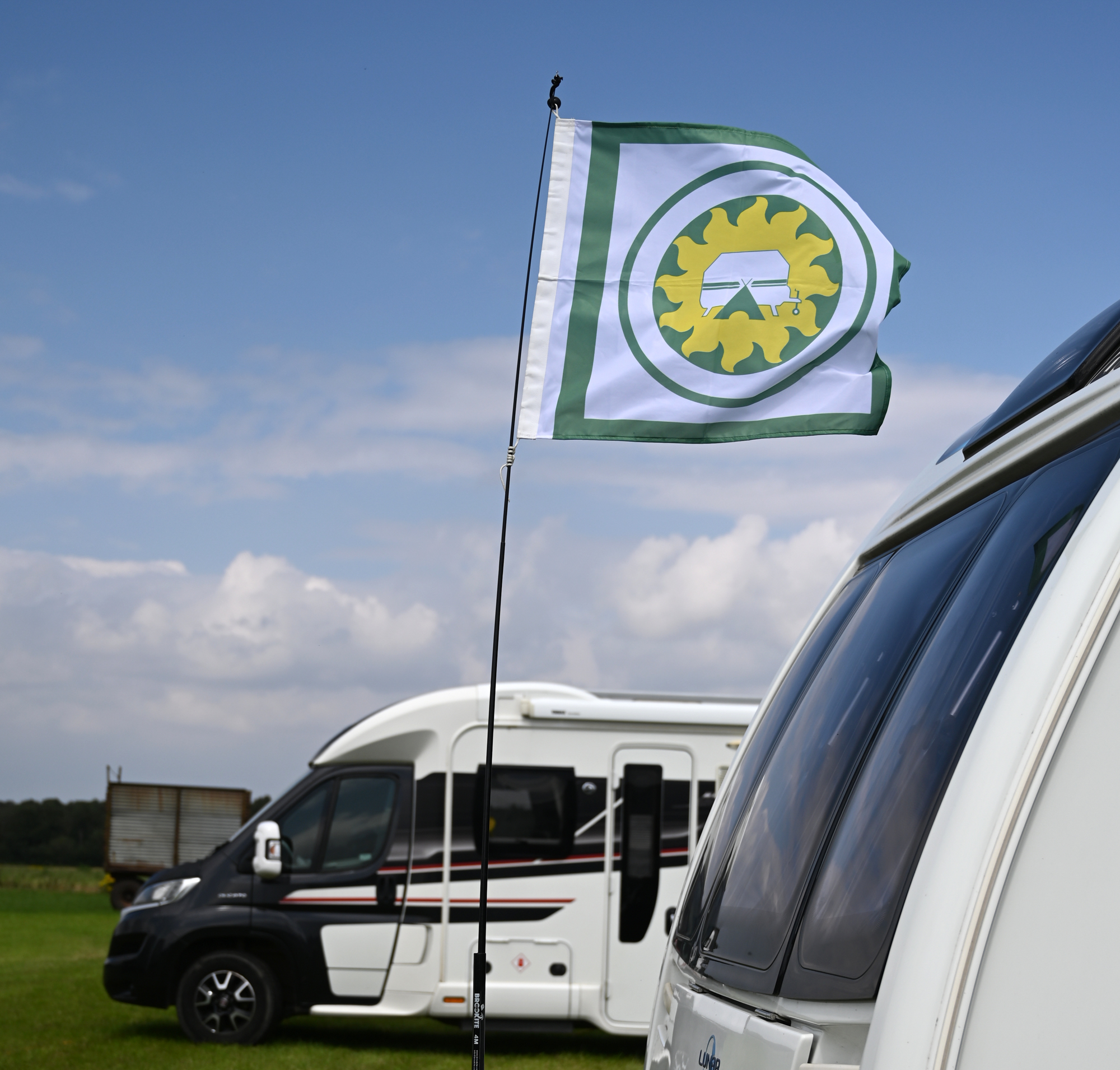 A flag blowing in the wind between caravans. At a U.K. Naturist Club event held by Suntreckers.